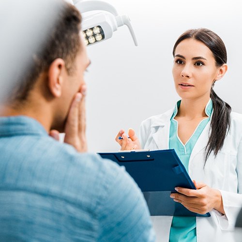 dentist talking to patient with dental emergency in Dallas