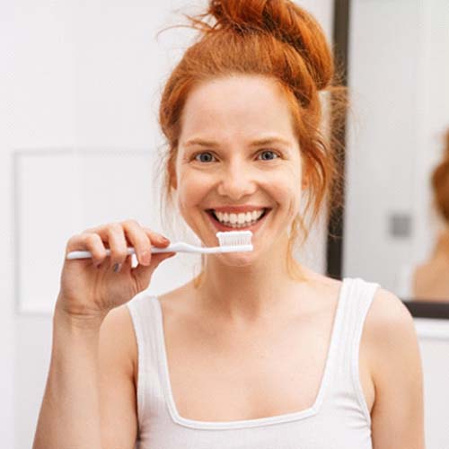 Woman holding a toothbrush and smiling