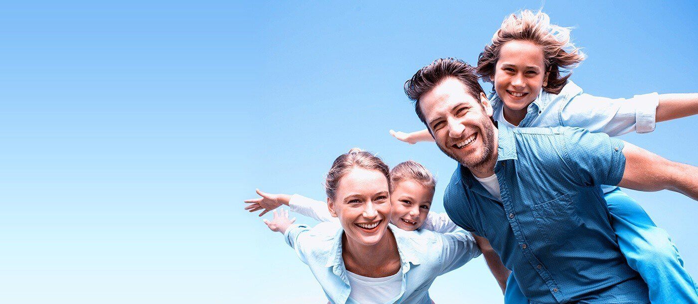 Family of four laughing outdoors