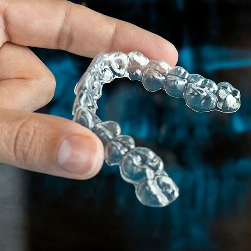 hand holding an aligner for Invisalign in North Dallas 