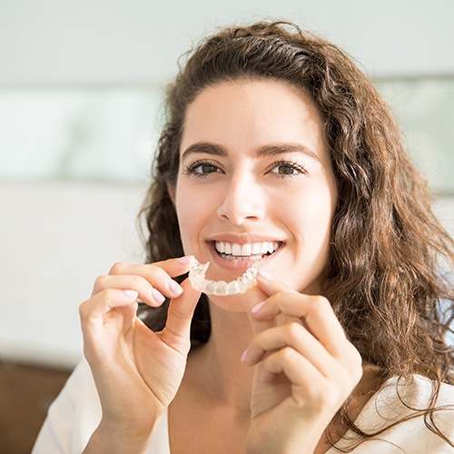 Woman placing Invisalign tray