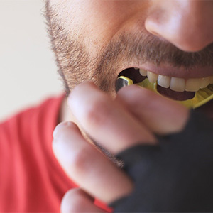 wearing mouthguard to prevent dental emergencies in Dallas 