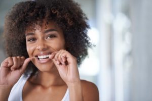 a woman flossing her teeth