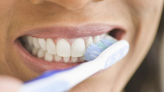 closeup of person smiling while brushing teeth